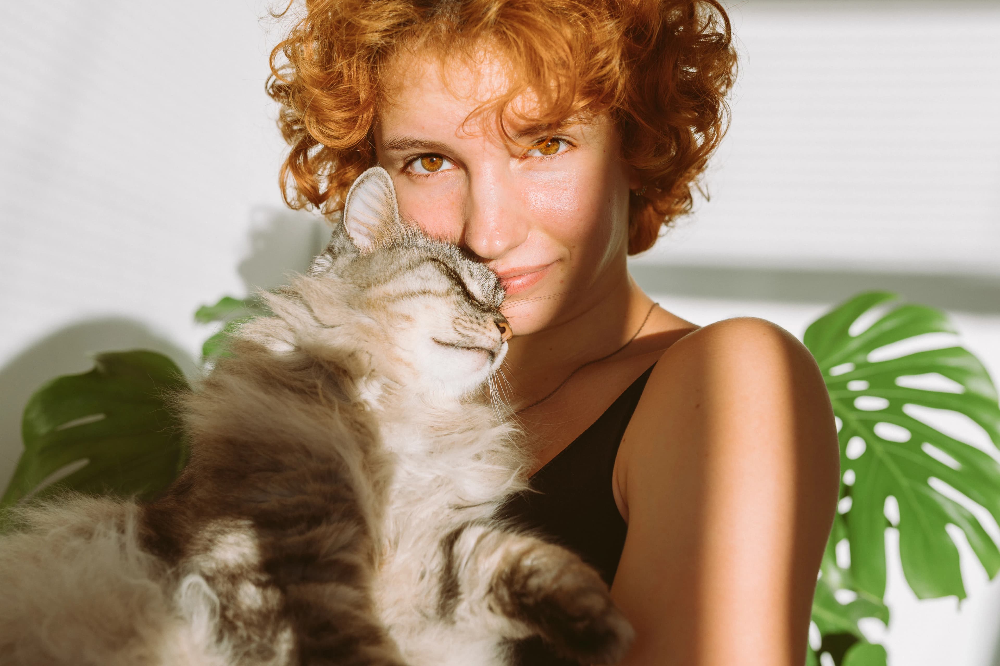 A woman holding her cat close in a quiet moment at home